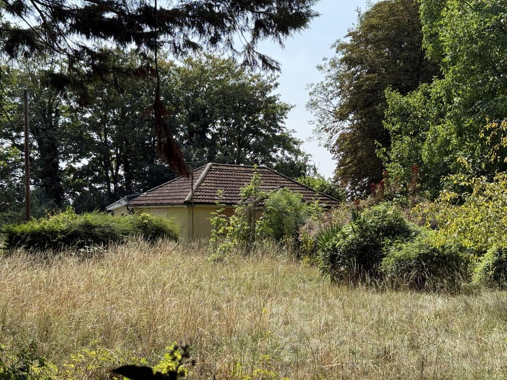 Lot: 121 - FREEHOLD DETACHED BUNGALOW WITH SEPARATE WORKSHOP AND GARAGE ON PLOT OF 0.83 ACRES FOR IMPROVEMENT OR REDEVELOPMENT - Land garden and trees with bungalow